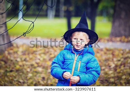little boy in halloween costume playing with spider web at fall, halloween concept