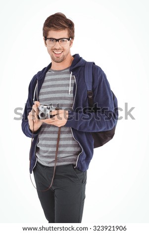 Portrait of happy man with camera standing against white background