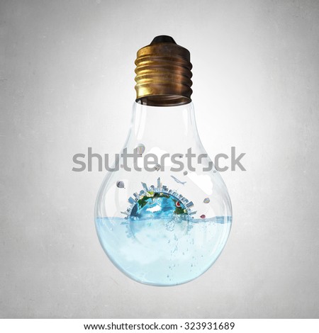 Glass light bulb filled with water and floating Earth planet. Elements of this image are furnished by NASA 