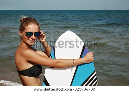 Portrait of beautiful blond active woman spending summer holidays on the beach, enjoying kite board.