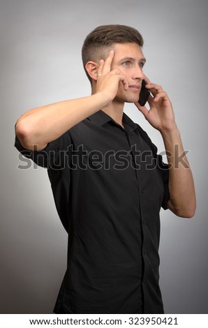 young stylish man calling by phone against grey background