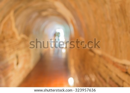 blur image of tunnel and light at the end.