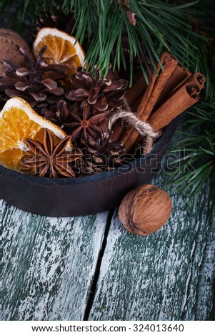 Christmas decoration card with evergreen fir tree, cones, cinnamon on rustic wooden background. Selective focus, shallow dof