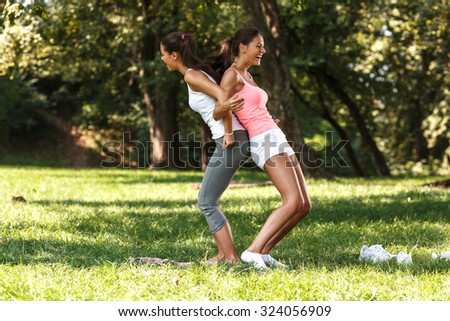 Two female friends stretching back and laughing