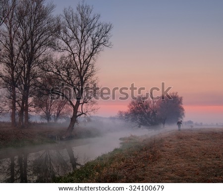 Photographer in the fog at sunrise