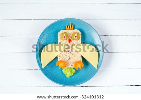 Food for kids: funny sandwich on blue plate on white background
