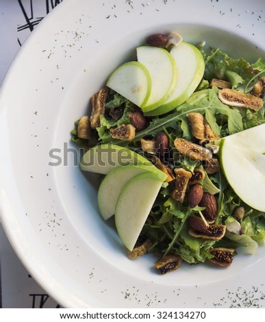 Healthy spinach and arugula salad with cilantro, dried figs, spiced almonds and apple served with a lite vinaigrette.