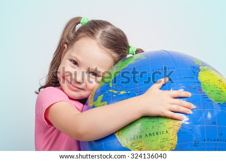 cute little girl hugging globe. save the earth concept. Royalty-Free Stock Photo #324136040