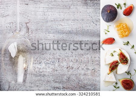 Cheese Board,appetizer.Brie cheese,figs,blueberries,honey and thyme and white wine.Copy space.selective focus