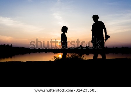 Man and girl on dark sunset background ,Father and Daughter wait for take photo of sunset