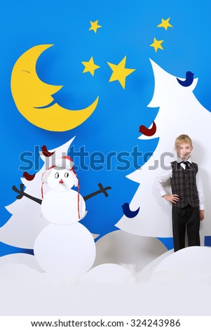 Cheerful boy in a cartoon fairy snowy forest. The magic of Christmas night. Full length portrait.