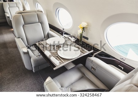 Luxury interior in bright colors of genuine leather in the business jet Royalty-Free Stock Photo #324258467