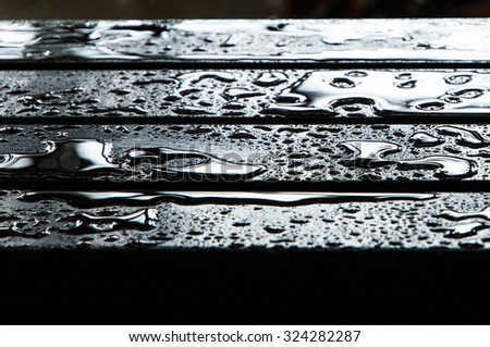 The water drops on wooden garden table, center focus for background. 