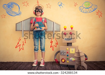 Happy kid playing with toy robot at home. Innovation technology and success concept Royalty-Free Stock Photo #324288134