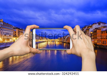 Girl taking pictures on mobile smart phone in Florence, Ponte Vecchio