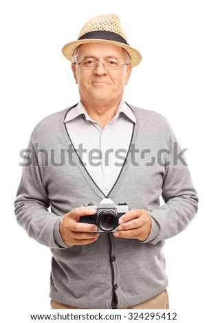 Vertical shot of a senior gentleman holding a camera and smiling isolated on white background