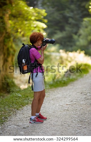 Woman professional nature photographer taking photos outdoor