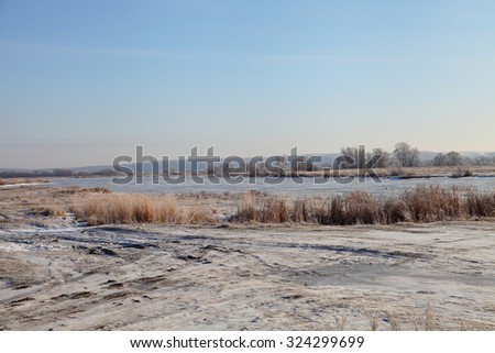 Winter landscape with river and trees in hoarfrost