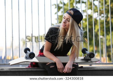 Young woman with skating board outside