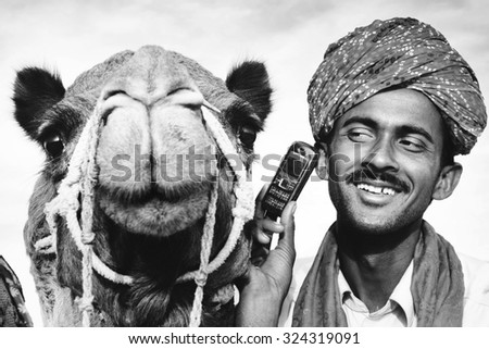Asian Man and Camel in the Desert with Communications Concept