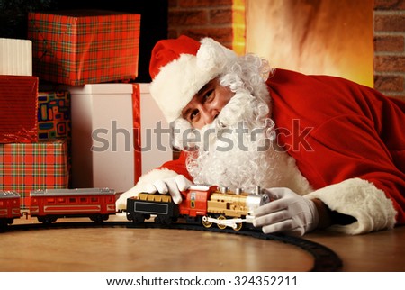 Santa Claus playing with toys under the Christmas tree.