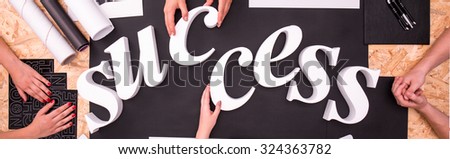 Group of people is making a word on a desk 