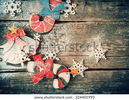 Toned image with Vintage Christmas Wooden Fir Tree Toys Candy Canes, Bell and Snowflakes on Wooden Background