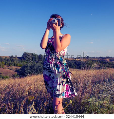 girl photographer photographing landscape at sunset