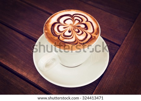 Cup of Cappuccino Coffee on a wooden table. Art Cappuccino.