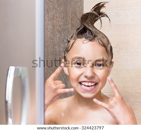 Cheerful beautiful girl bathing under a shower at home
