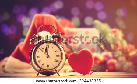 Alalrm clock and heart shape toy on Christmas background 