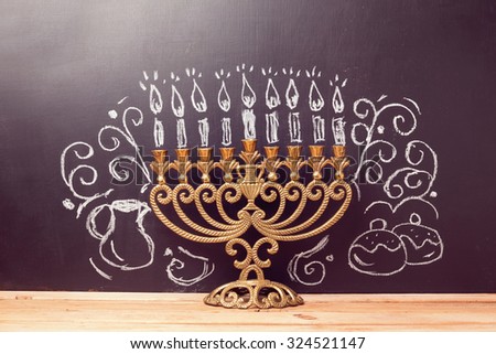 Creative Jewish holiday Hanukkah background with menorahl over chalkboard with hand drawing