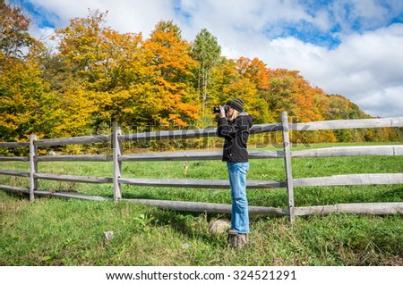Woman taking a photograph of the fall color in the Adirondack mountains