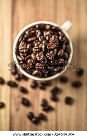 Coffee bean with white cup on wooden background