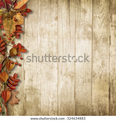 Autumn wooden background with a branch of mountain ash