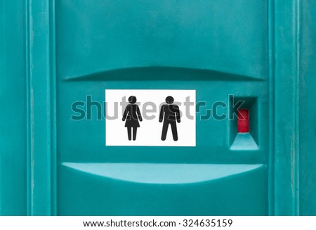 Public restroom/WC sign on a portable cabin. Male and female figures.