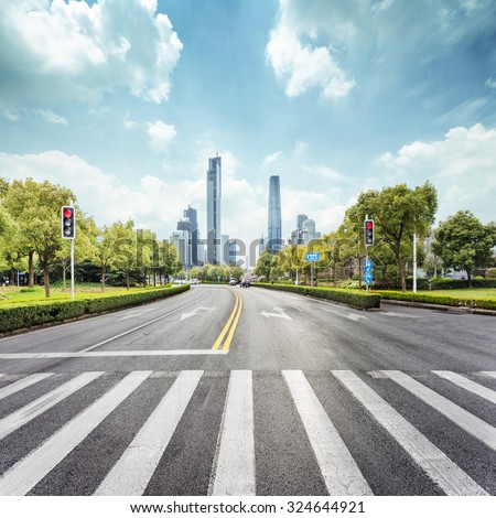 empty road with zebra crossing and skyscrapers in modern city Royalty-Free Stock Photo #324644921