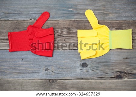 yellow and red construction gloves with raised thumb up