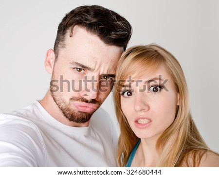 Attractive young couple friends woman and man taking selfie with smartphone or camera on white background