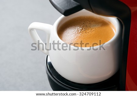 white cup of coffee in the coffee machine, close-up