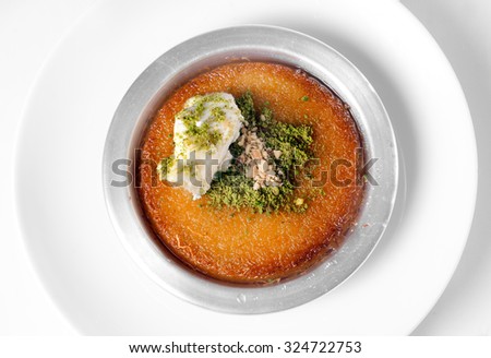 Delicious traditional Turkish dessert kunefe with pistachio powder over white background Royalty-Free Stock Photo #324722753