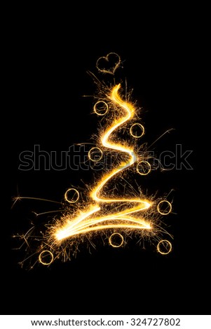 Sparkling christmas tree with christmas balls isolated on black background. Merry christmas.
