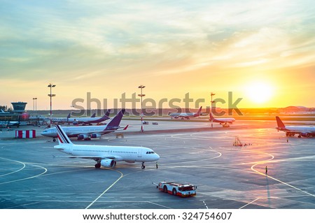 Airport with many airplanes at beautiful sunset Royalty-Free Stock Photo #324754607