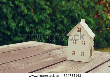 small house model over wooden table outdoors at garden selective focus . filtered image

