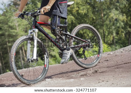 Mountain bike rider with leg prosthesis. Unfiltered version.
 Royalty-Free Stock Photo #324771107