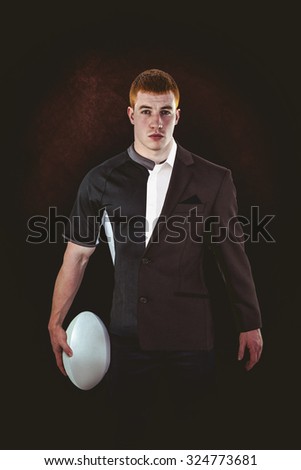Rugby player holding a rugby ball against half a suit