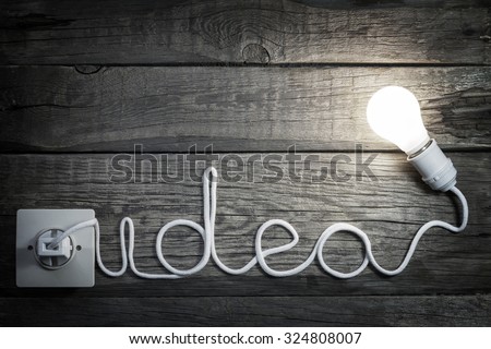Creativity concept idea letters with bulb and wire abstract background