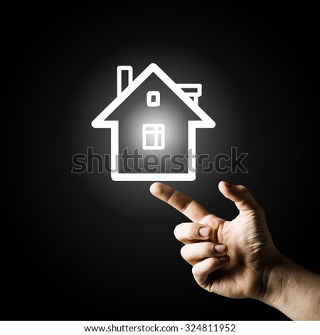 Close up of man hand pointing with finger at house model