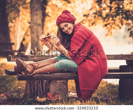 Beautiful woman wearing knitted coat in autumn park 