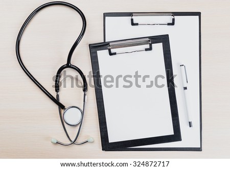 Stethoscope, clipboard on wooden background
